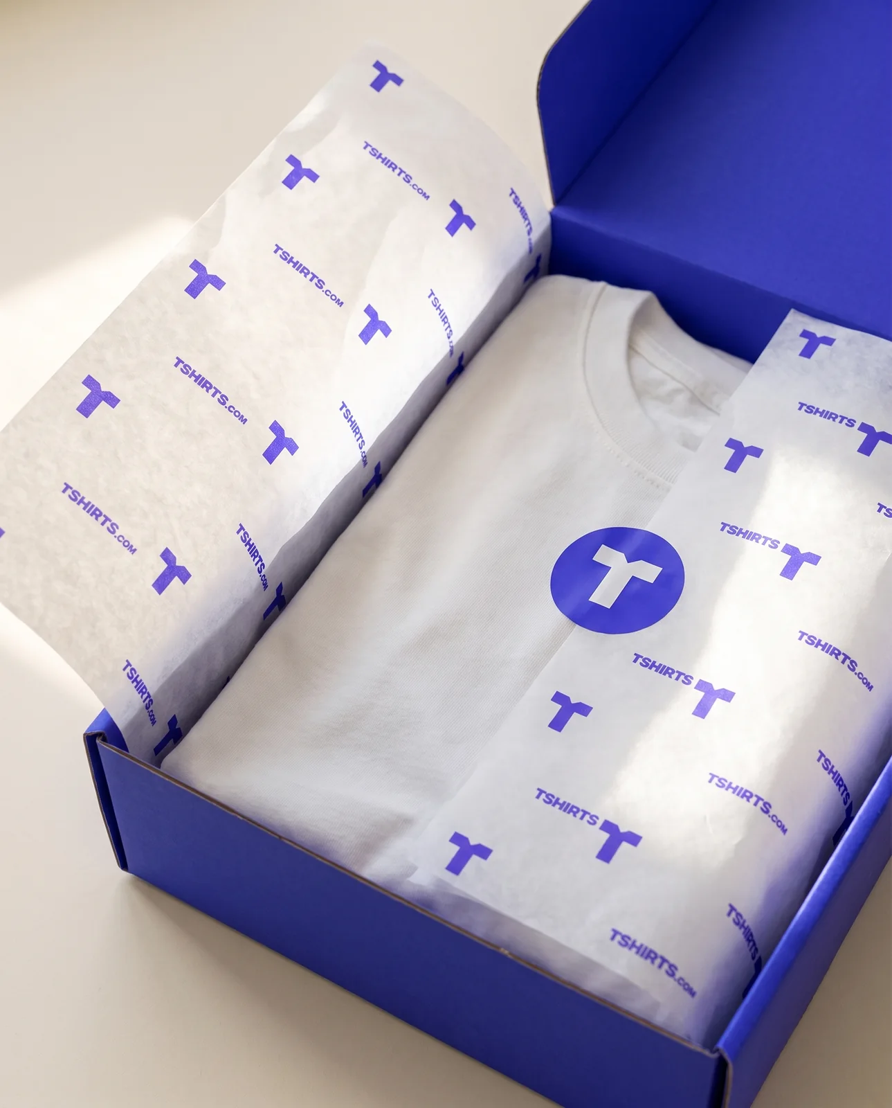 White tissue paper with an electric-blue T and wordmark pattern